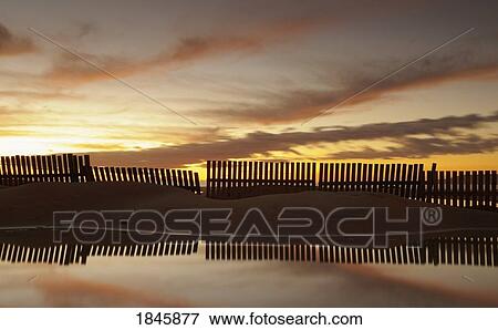 Fence reflecting in the water at sunset View Large Photo Image Stock Photo - Fence reflecting in the water at sunset. Fotosearch