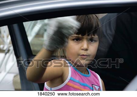 Stock Image - Girl cleaning car window. Fotosearch