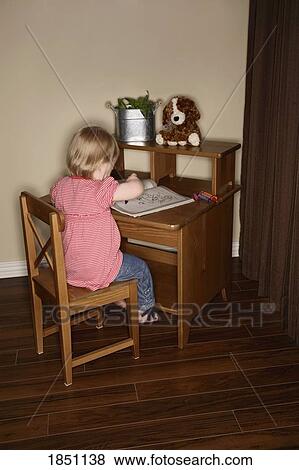 Girl coloring at her desk View Large Photo Image Stock Photo - Girl coloring at her desk. Fotosearch