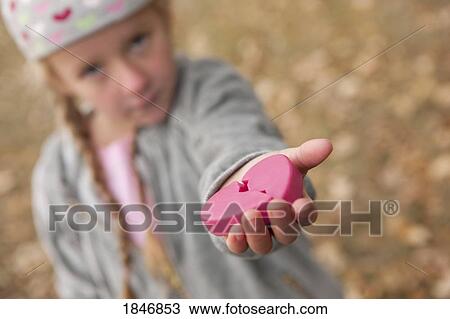 Stock Image - Girl holding broken heart. Fotosearch