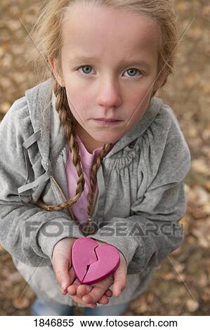 Stock Photography - Girl holding broken heart. Fotosearch