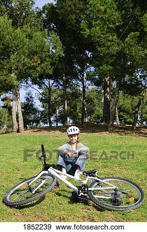 Girl sitting by her bike View Large Photo Image Stock Photo - Girl sitting by her bike. Fotosearch