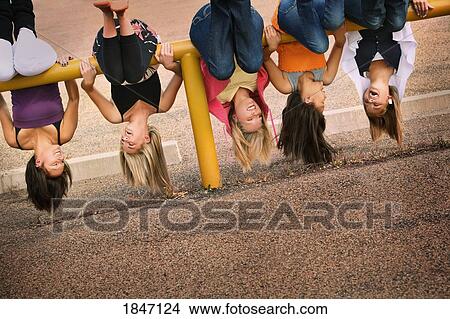 Picture - Girls hanging upside down. Fotosearch