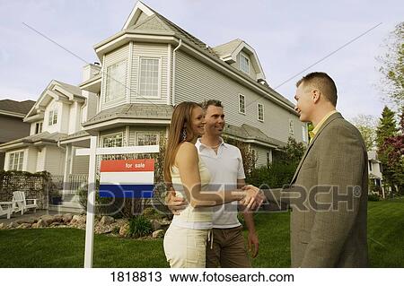 Stock Image - Home for sale; Real estate agent with clients. Fotosearch