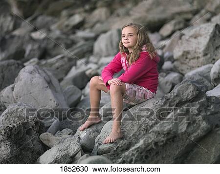 Honokohau Bay, Maui, Hawaii, USA; Young girl sitting on rocks View Large Photo Image Stock Image - Honokohau Bay, Maui, Hawaii, USA; Young girl sitting on rocks. Fotosearch