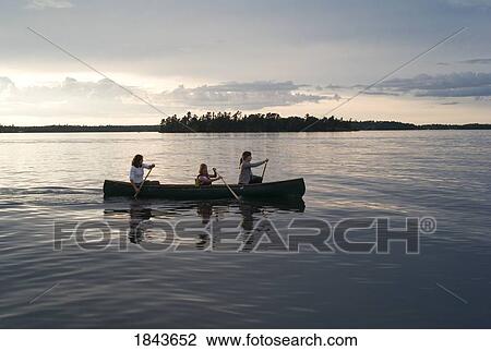 Stock Image - Lake of the Woods, Ontario, Canada; Three people canoeing. Fotosearch