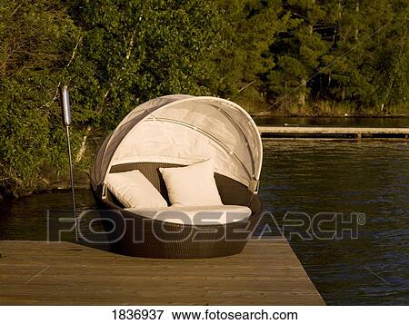 Stock Photo - Lake of the Woods, Ontario, Canada; Lounging chair on a dock. Fotosearch