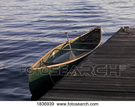 Stock Photo - Lake of the Woods, Ontario, Canada; Canoe next to a dock. Fotosearch
