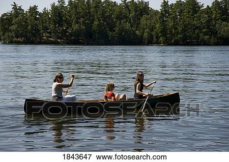 Stock Photo - Lake of the Woods, Ontario, Canada; Three people canoeing. Fotosearch
