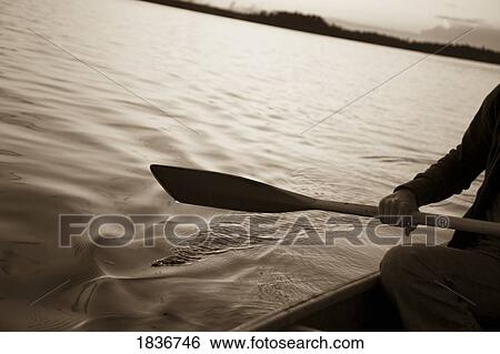 Stock Photograph - Lake of the Woods, Ontario, Canada; Person canoeing on a lake. Fotosearch