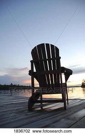 Stock Image - Lake of the Woods, Ontario; Lounge chair on dock. Fotosearch