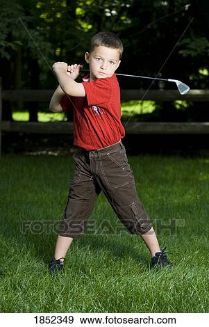 Stock Photo - Little golfer; Young boy with a golf club. Fotosearch