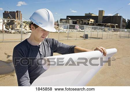 Stock Photo - Looking at construction site plans. Fotosearch