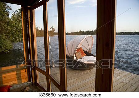 Stock Image - Lounging chair on a dock. Fotosearch