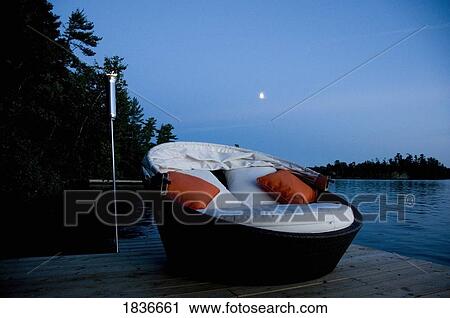 Stock Image - Lounging chair on a dock. Fotosearch