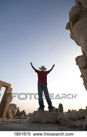 Stock Photography - Luxor, Egypt; The Ramesseum, Man with his arms raised. Fotosearch