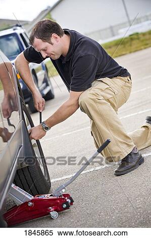 Stock Photography - Man changing a tire. Fotosearch