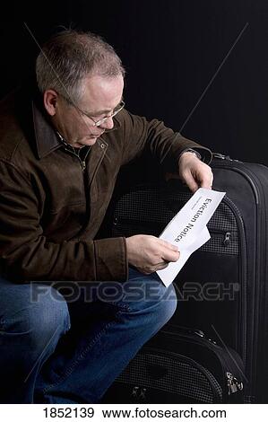 Stock Photo - Man holding an eviction notice; Man moving out. Fotosearch