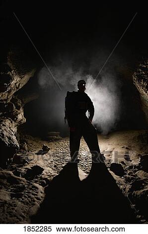 Stock Photography - Man in a cave; spelunking. Fotosearch