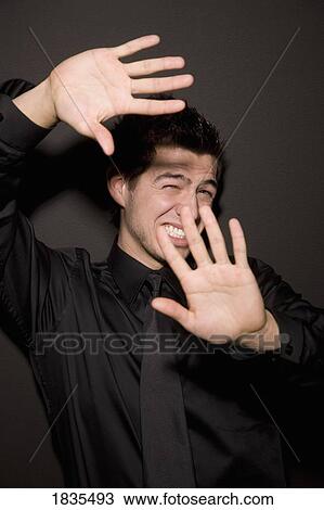 Stock Image - Man with hands blocking light. Fotosearch