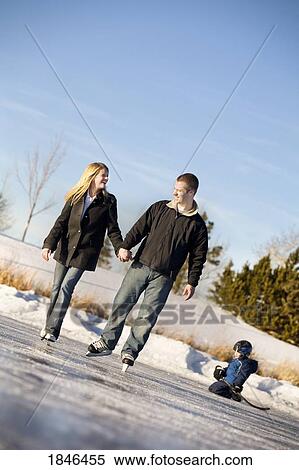 Stock Photography - Man, woman and child; Couple skating with child . Fotosearch