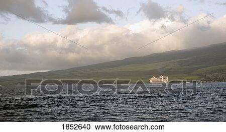 Stock Image - Maui, Hawaii, USA; Boat against shoreline and hills . Fotosearch