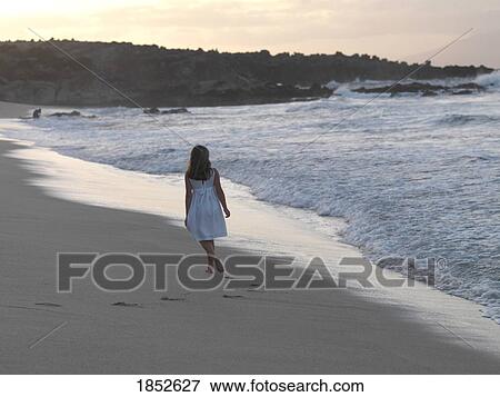 Stock Photo - Maui, Hawaii, USA; Girl walking on the beach . Fotosearch