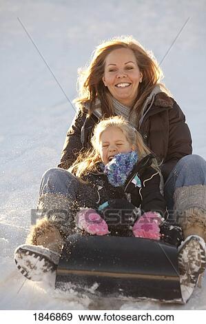 Stock Photo - Mother and daughter tobogganing. Fotosearch