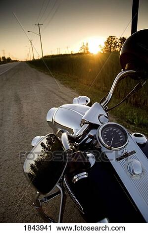 Motorcycle parked on the side of the road at sunset View Large Photo Image Stock Image - Motorcycle parked on the side of the road at sunset. Fotosearch