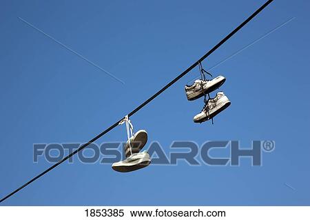 Pairs of shoes hanging from utility line View Large Photo Image Stock Photography - Pairs of shoes hanging from utility line. Fotosearch
