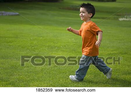 Stock Photo - Park; Boy running on grass. Fotosearch