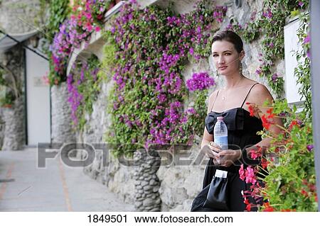Positano, Campania, Italy; Woman standing along a stone wall with vines View Large Photo Image Stock Image - Positano, Campania, Italy; Woman standing along a stone wall with vines. Fotosearch