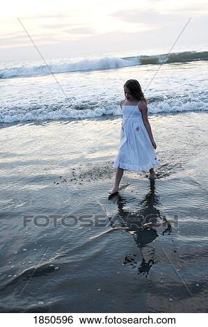 Stock Photograph - Puerto Vallarta, Mexico; Girl walking in the water . Fotosearch