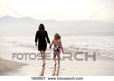 Stock Photo - Puerto Vallarta, Mexico; Mother and daughter walking on the beach. Fotosearch