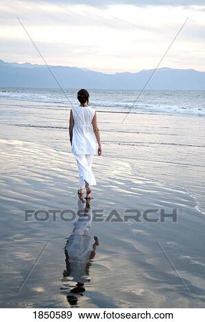 Stock Photo - Puerto Vallarta, Mexico; Woman walking along the beach. Fotosearch