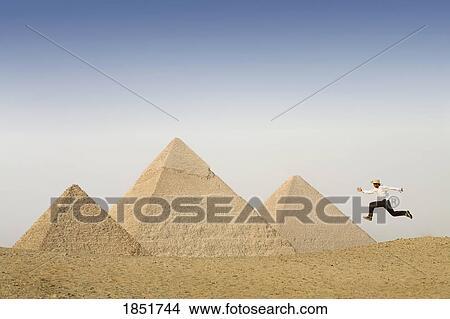 Pyramids of Giza, Cairo, Egypt; man leaping in front of the pyramids View Large Photo Image Picture - Pyramids of Giza, Cairo, Egypt; man leaping in front of the pyramids. Fotosearch
