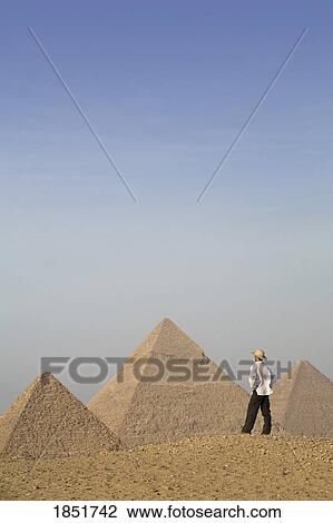 Pyramids of Giza, Cairo, Egypt; tourist looks out towards the pyramids View Large Photo Image Stock Image - Pyramids of Giza, Cairo, Egypt; tourist looks out towards the pyramids. Fotosearch