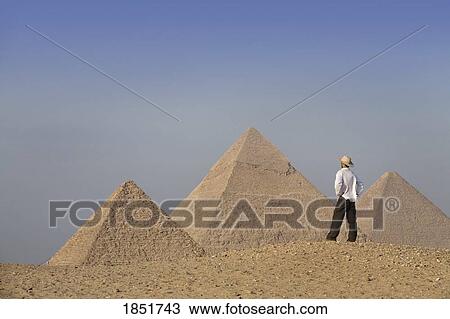 Stock Image - Pyramids of Giza, Cairo, Egypt; tourist looks out towards the pyramids. Fotosearch