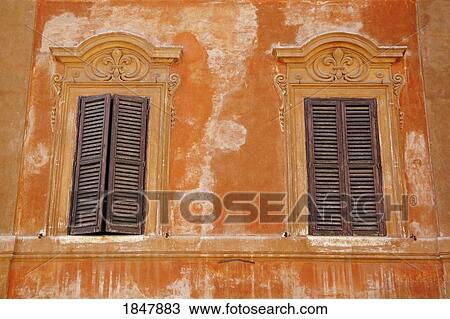 Stock Image - Rome, Italy; Two windows with shutters. Fotosearch