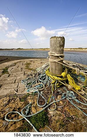 Stock Image - Ropes tied around a mooring bollard. Fotosearch