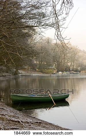 Rowboat sitting at the shore of a lake, Cumbria, England View Large Photo Image Stock Photo - Rowboat sitting at the shore of a lake, Cumbria, England. Fotosearch