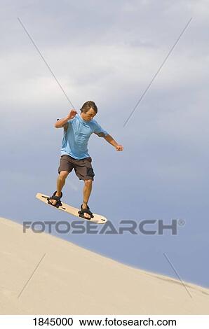Stock Image - Sandboarder, Honeyman State Park near Florence, Oregon, USA . Fotosearch