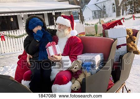 Stock Photo - Santa Claus giving gifts on his sled. Fotosearch