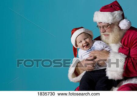 Stock Image - Santa Claus with a baby. Fotosearch