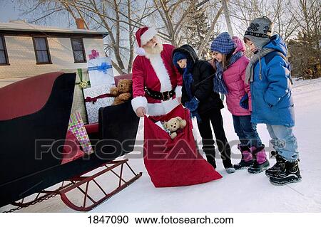 Santa giving gifts to children View Large Photo Image Stock Image - Santa giving gifts to children. Fotosearch