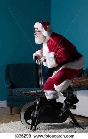 Stock Photo - Santa riding stationary bike. Fotosearch