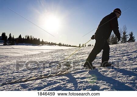 Silhouette of a man; Man pulling a toboggan View Large Photo Image Stock Photo - Silhouette of a man; Man pulling a toboggan. Fotosearch