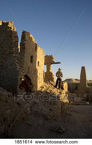 Picture - Siwa Oasis, Egypt; Man wearing a hat at the Temple of the Oracle of Amun. Fotosearch