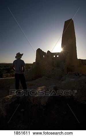 Stock Image - Siwa Oasis, Egypt; Man wearing a hat at the Temple of the Oracle of Amun. Fotosearch