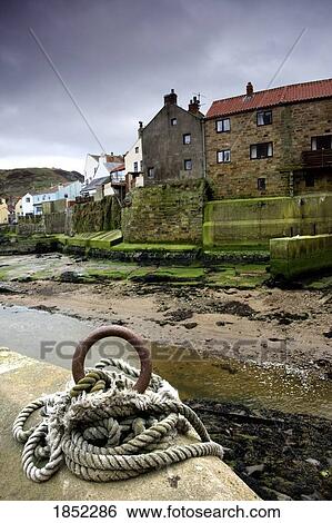 Stock Photograph - Staithes, Yorkshire, England; Rope tied to pier by beach. Fotosearch